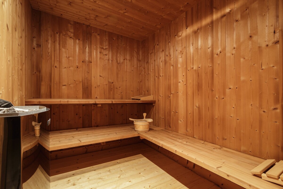 A wooden sauna with a bucket on the bench