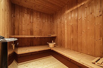 A wooden sauna with a bucket on the bench