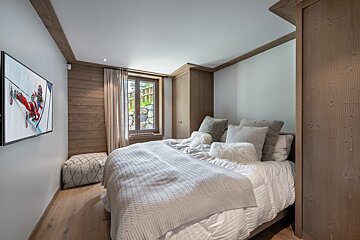 A bedroom with a large bed and a flat screen tv