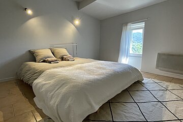 A bedroom with a large bed and a window