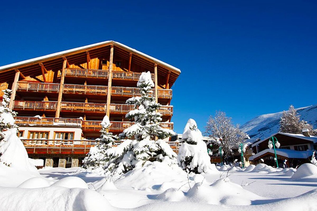 Snow covered trees in front of a large building