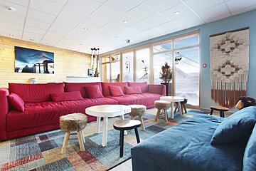 A living room with a red couch and a blue couch