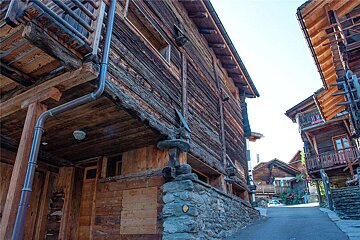 A wooden building with a yellow arrow pointing to the right