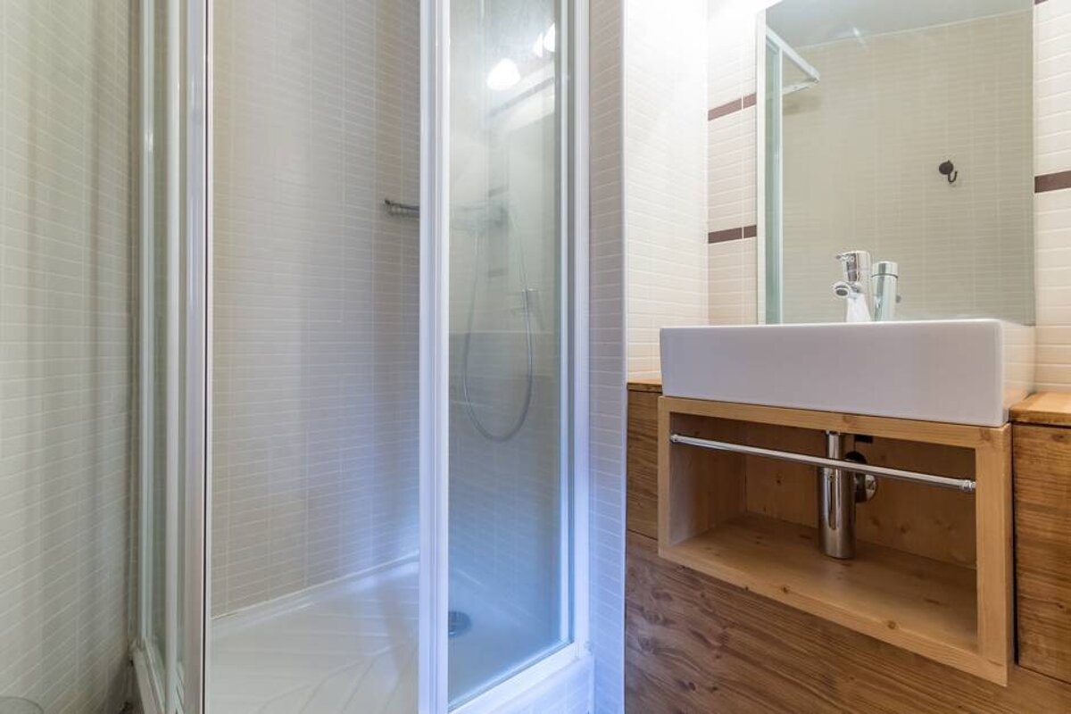 A bathroom with a sink and a walk in shower