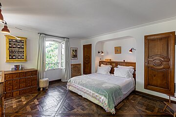 A bedroom with a bed and a dresser with drawers