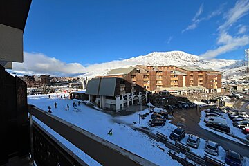 A view of a snowy ski resort with a large building in the background