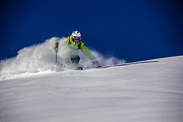 A person is skiing down a snow covered slope