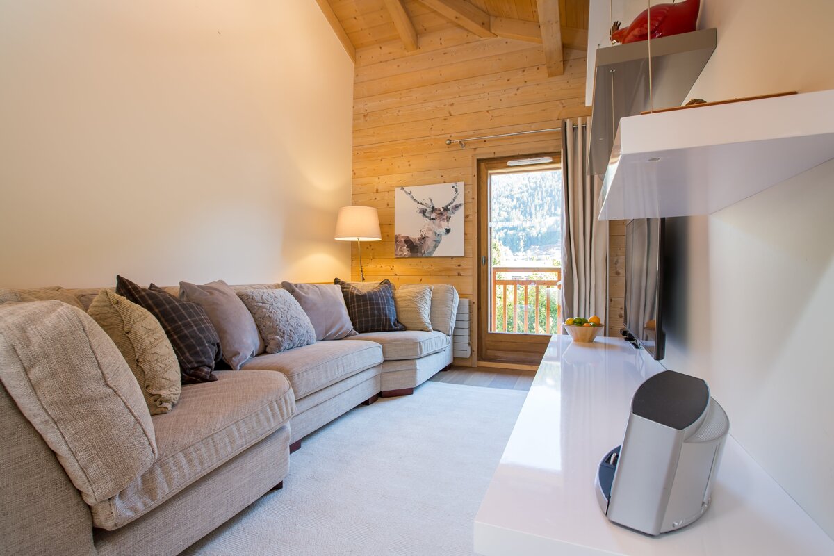 A living room with a couch and a picture of a deer on the wall