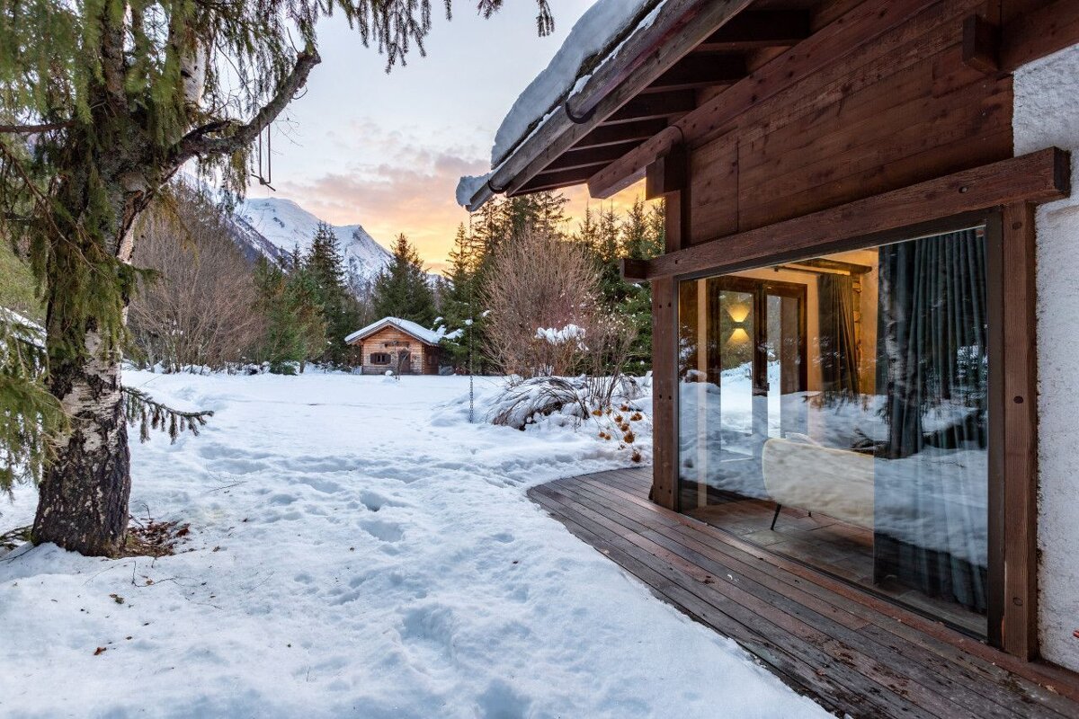 A cabin in the snow with a mountain in the background