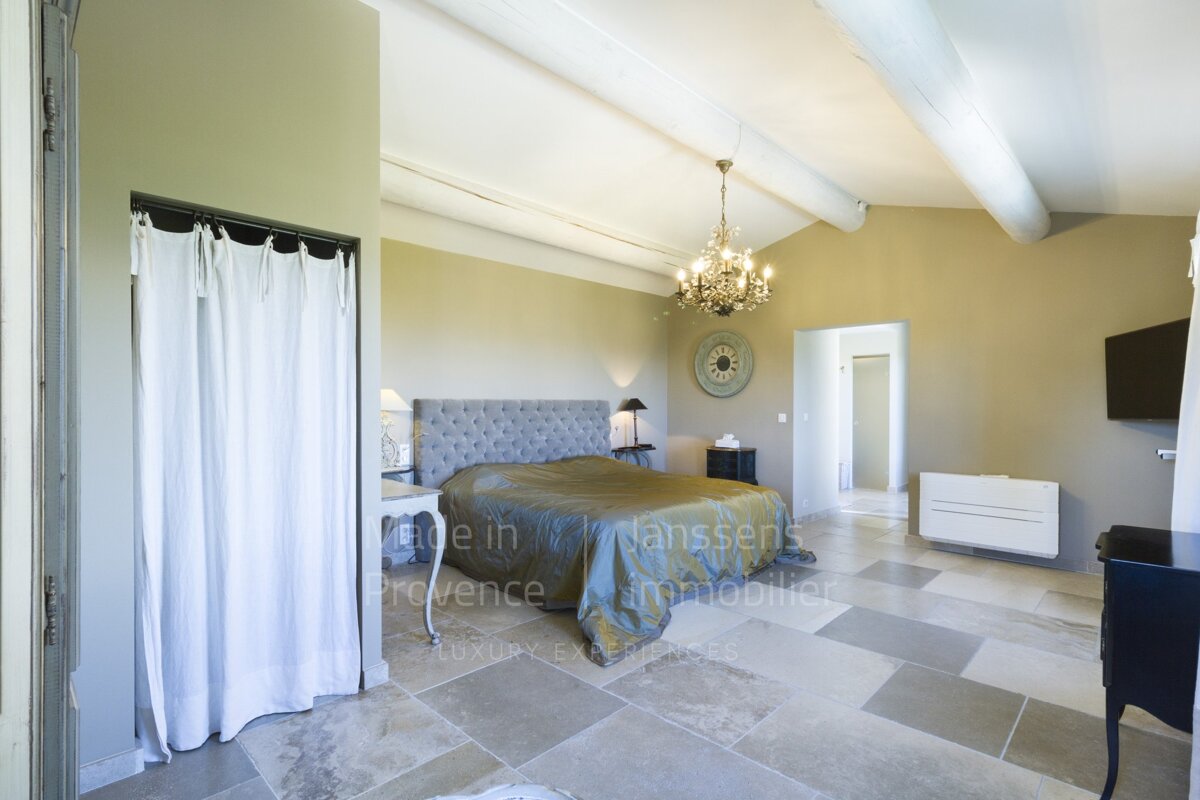 A bedroom with a clock on the wall that says made in provence