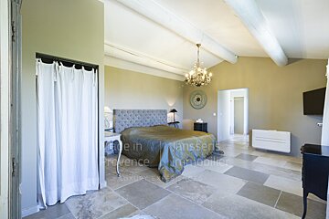 A bedroom with a clock on the wall that says made in provence