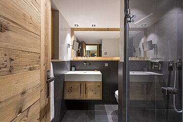 A bathroom with a wooden door and a sink