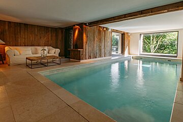 A large swimming pool in a room with a couch
