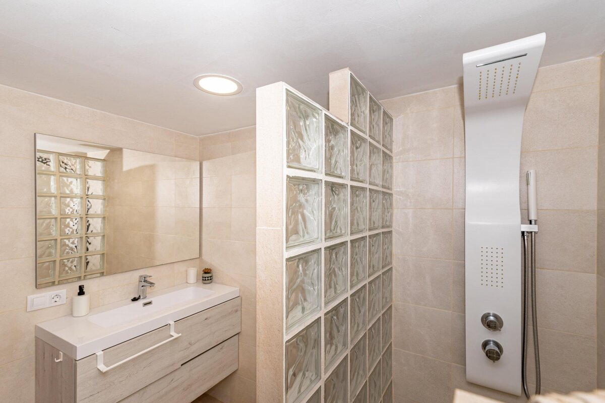 A bathroom with a sink a mirror and a shower