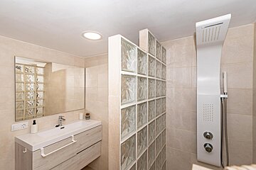 A bathroom with a sink a mirror and a shower