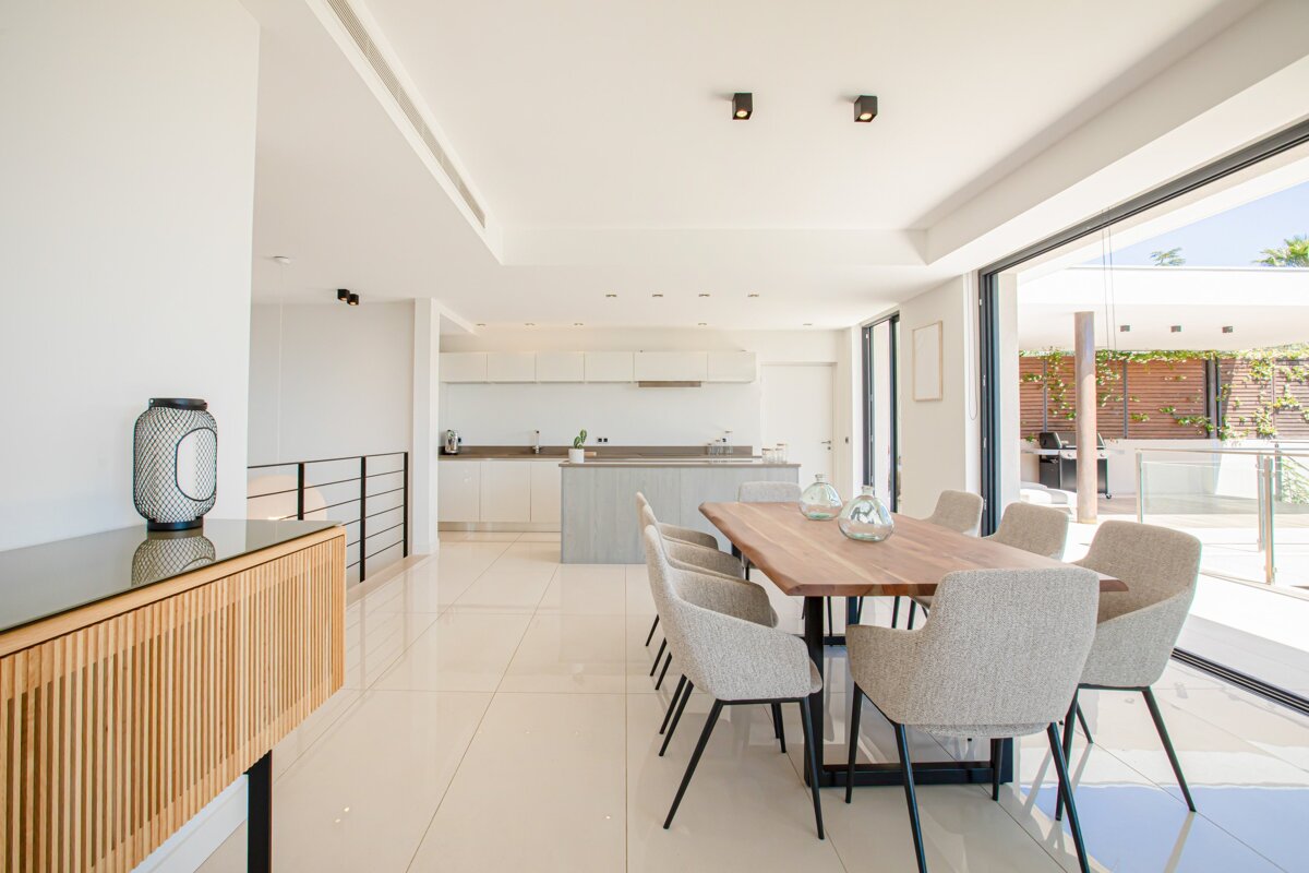 A dining room with a wooden table and white chairs
