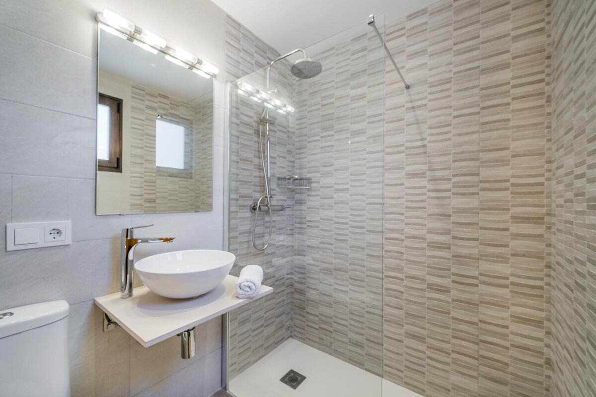 A bathroom with a sink and a walk in shower