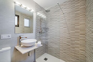 A bathroom with a sink and a walk in shower