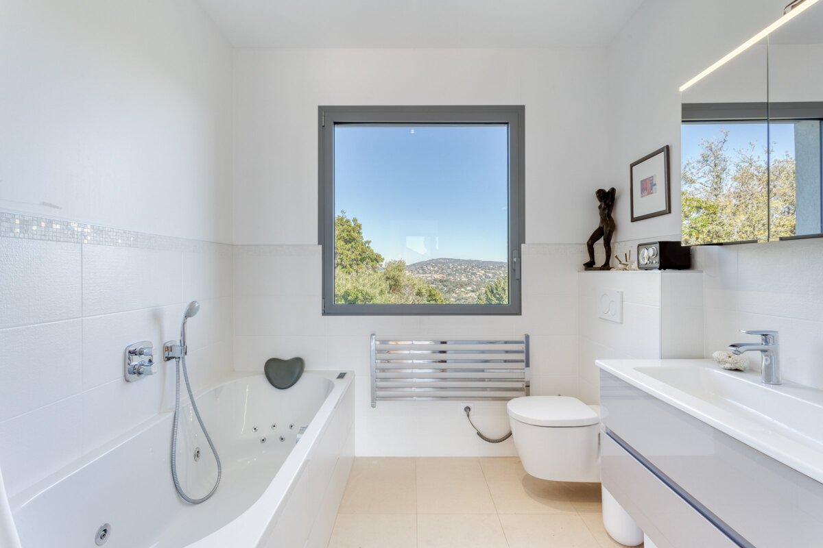 A bathroom with a bathtub toilet and a window