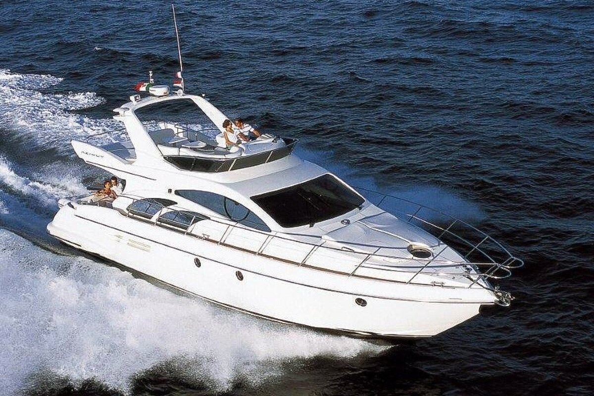 A white yacht is floating on top of a body of water