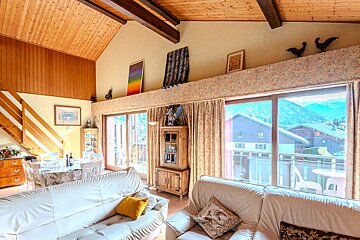 A living room with a couch and a rooster on the ceiling