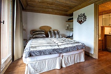 A bedroom with a bed and a clock on the wall