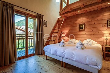 A hotel room with two beds and a balcony with a sign that says tengo