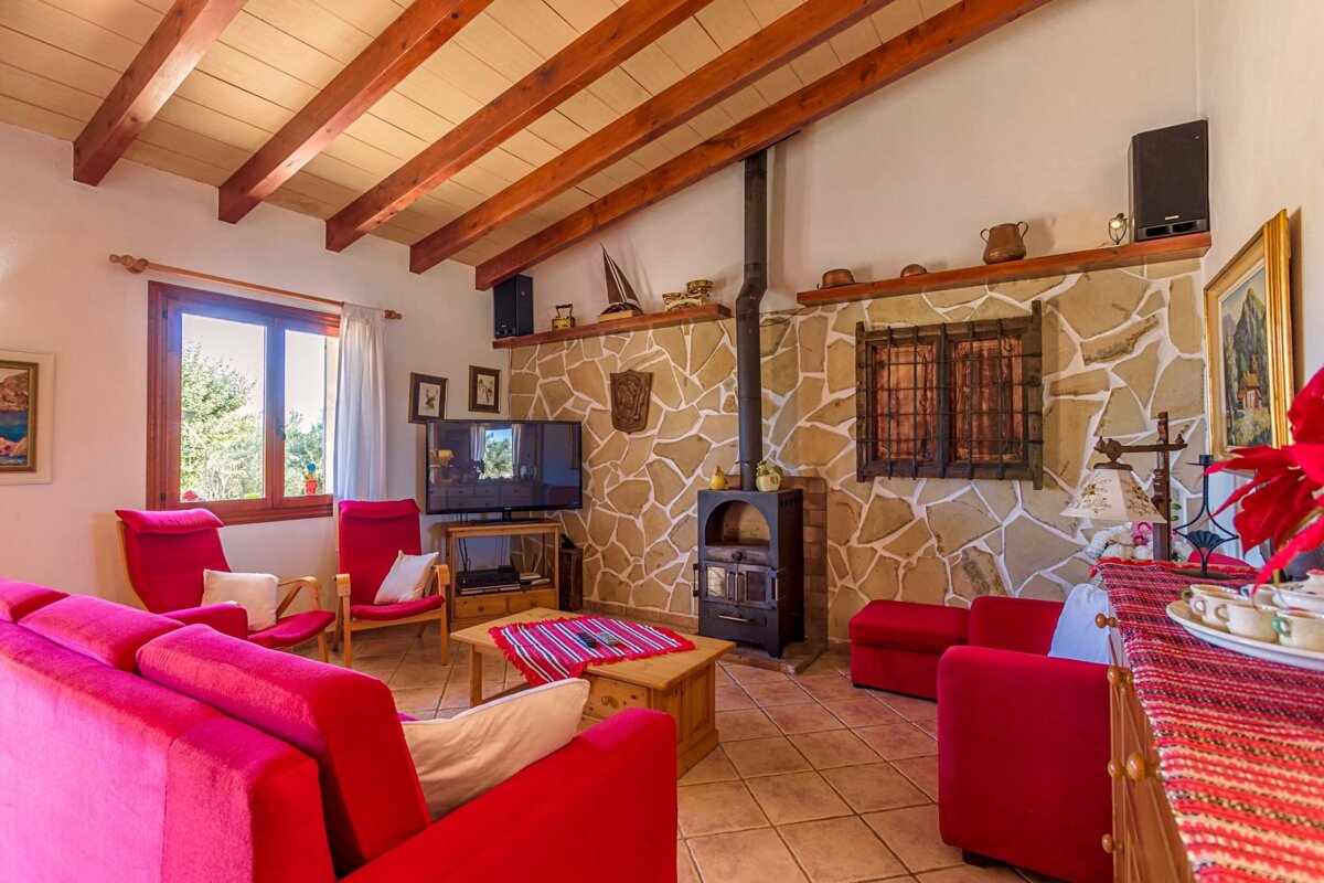 A living room with red furniture and a fireplace