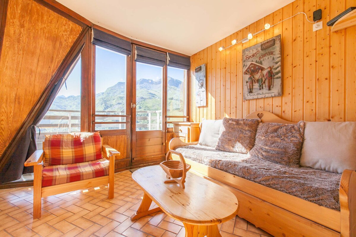 A living room with a couch and a chair and a painting on the wall that says 