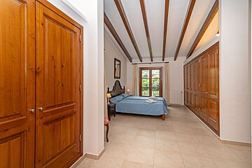 A bedroom with a blue bed and wooden doors