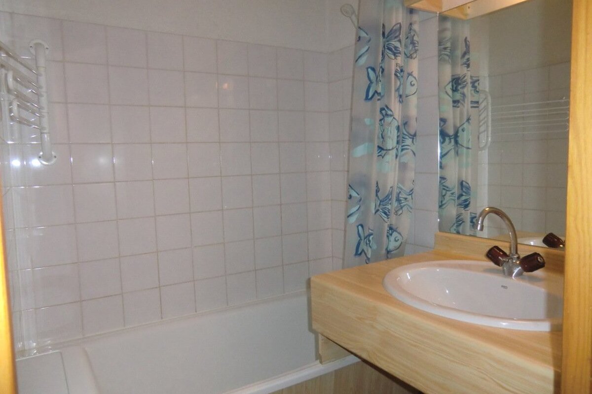 A bathroom with a blue shower curtain and a sink