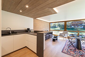 A kitchen with white cabinets and black counter tops