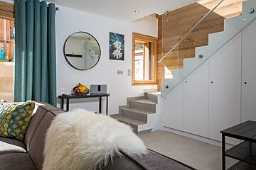 A living room with stairs leading up to the second floor