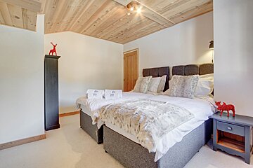 A bedroom with two beds and a deer on the wall