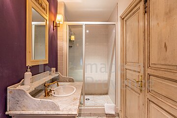 A bathroom with a purple wall and a sink and mirror