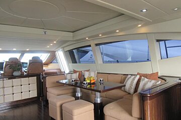 A dining area on a boat with a table and chairs