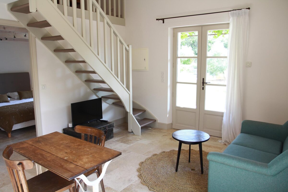 A living room with a staircase leading up to the second floor