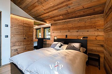 A bedroom with wooden walls and a bed with a deer pillow