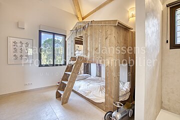 A bedroom with a bunk bed and a sign that says janssens immobilier
