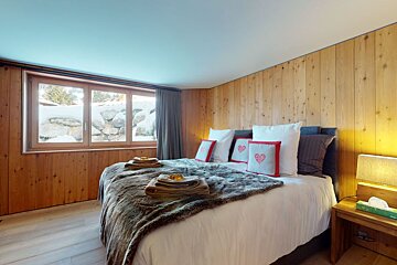 A bedroom with a bed and a nightstand with a tissue box on it