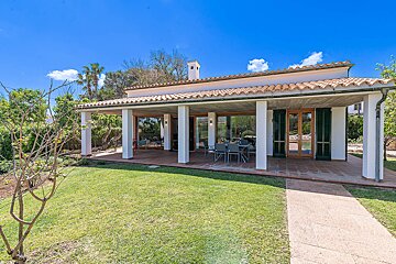 A house with a covered porch and a lawn in front of it
