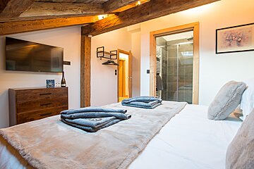 A bedroom with a large flat screen tv above the bed