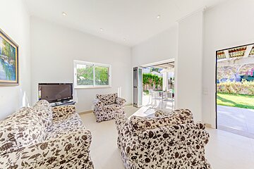 A living room with a couch and chairs and a flat screen tv