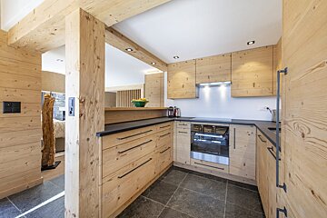 A kitchen with wooden cabinets and black counter tops