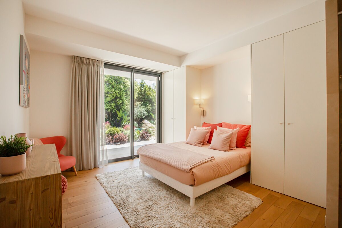 A bedroom with a pink bed and red pillows