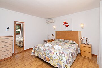 A bedroom with a large bed and two nightstands