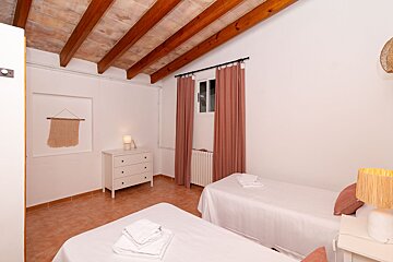 A bedroom with two beds and a dresser