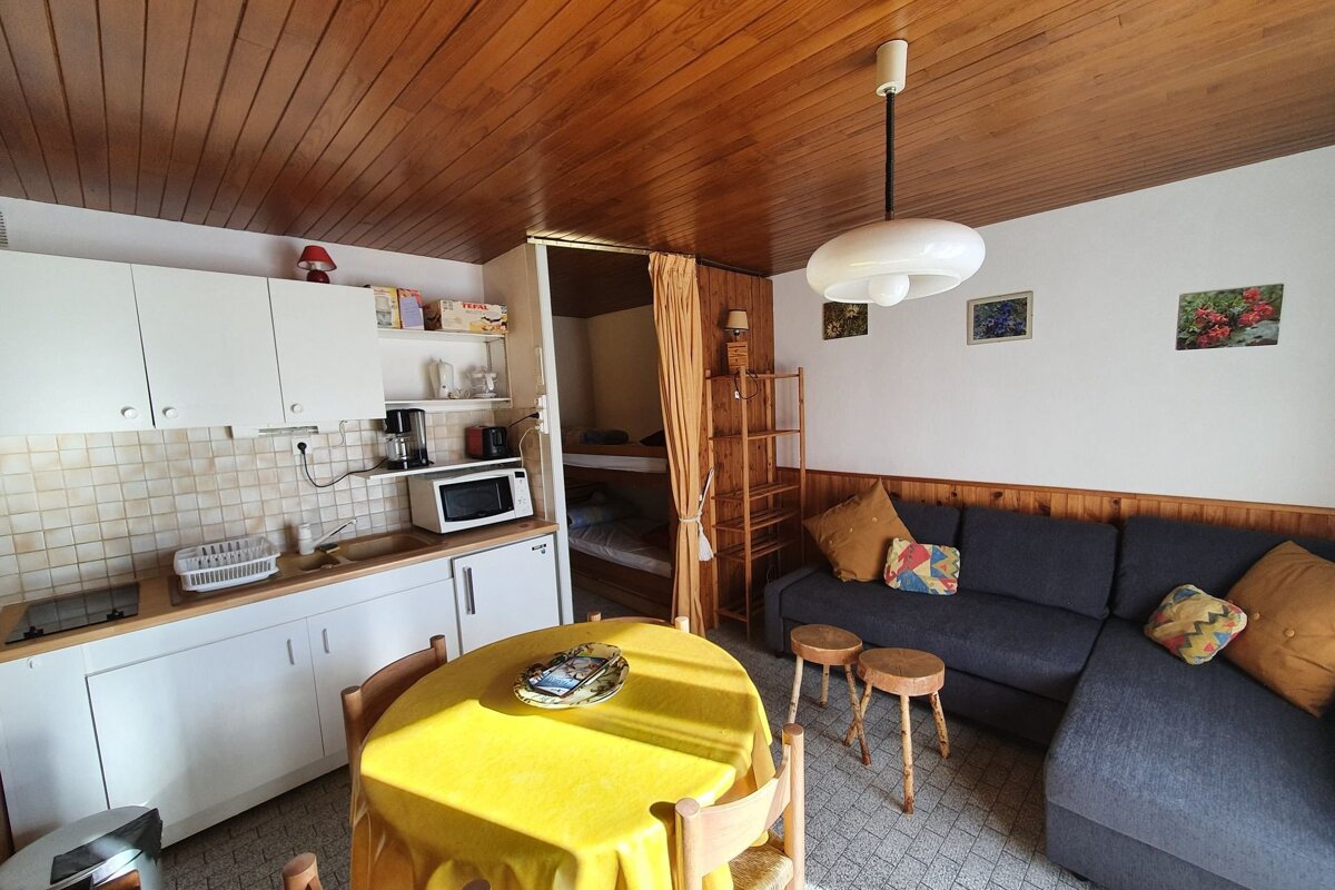 A kitchen with a yellow table cloth and a couch