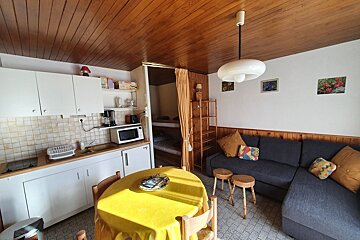 A kitchen with a yellow table cloth and a couch