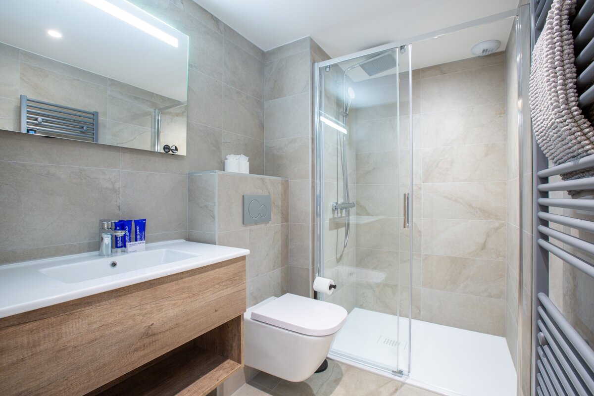 A bathroom with a toilet a sink and a shower